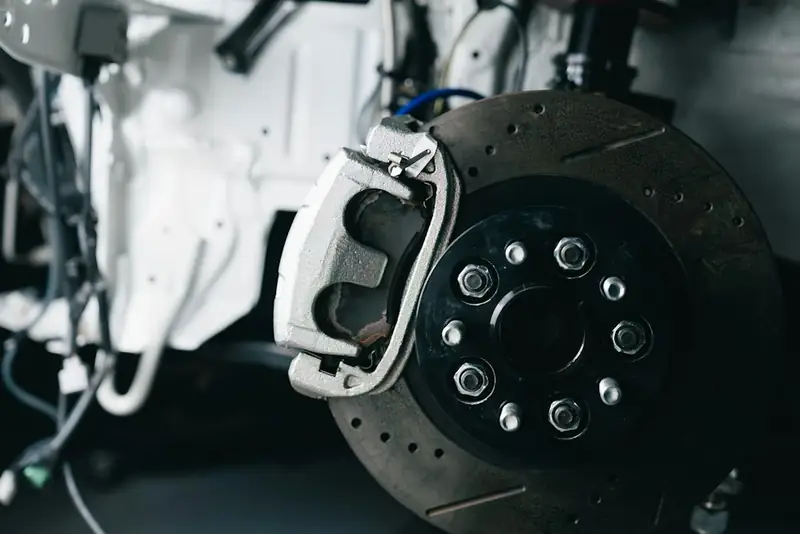 Close-up of a car brake rotor and caliper during repair